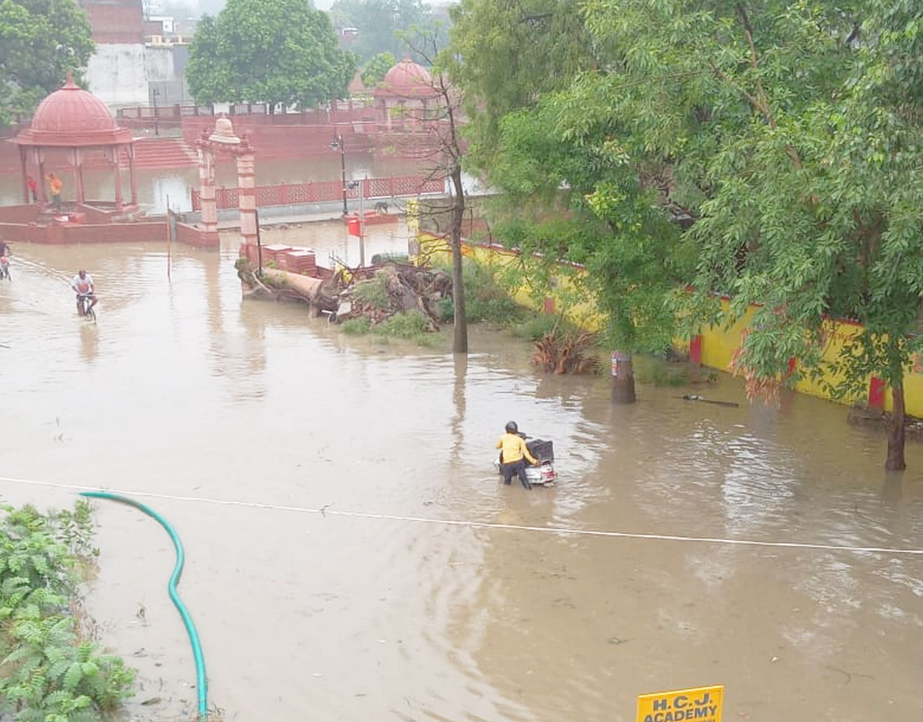 Saints and others passing through the waterlogged area due to rain water in Jalwanpura. 